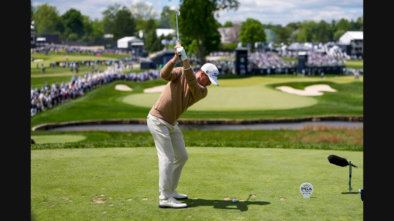 Photograph of a golfer mid-swing on a PGA Championship tee with a crowd and course behind him